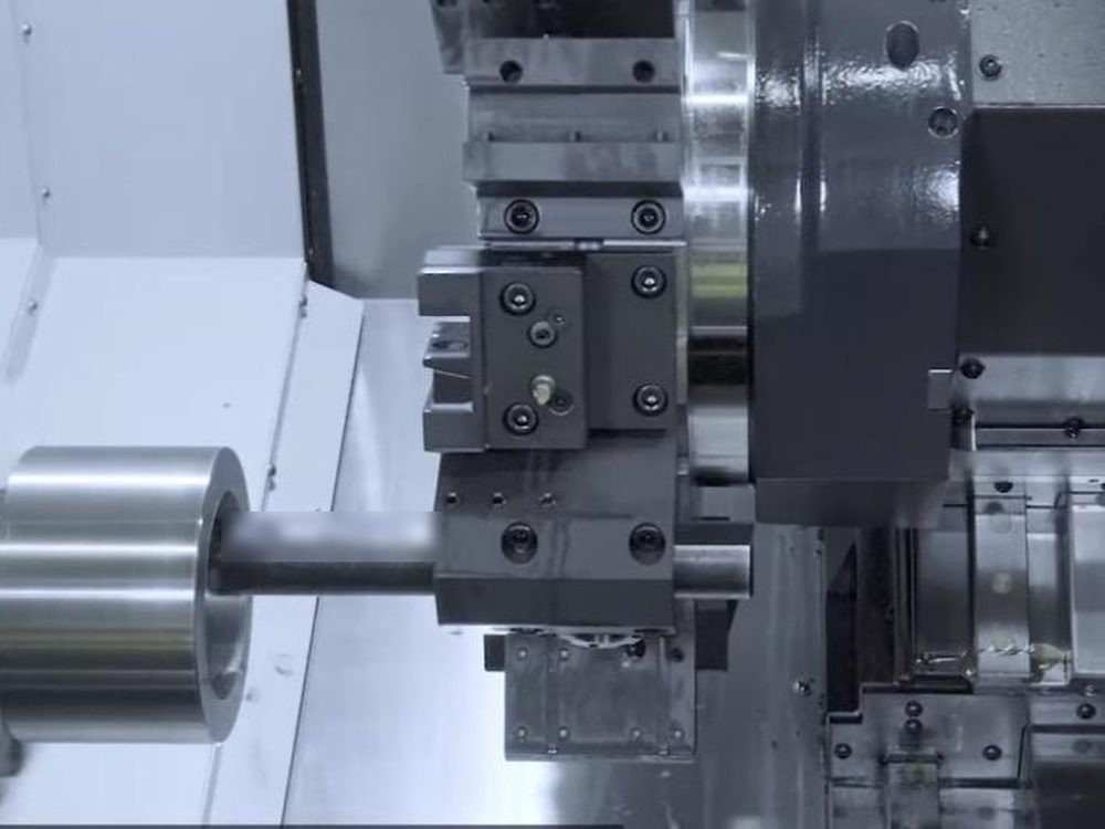 Inside an enclosed CNC lathe: a boring bar on the tool turret lined up with the chuck